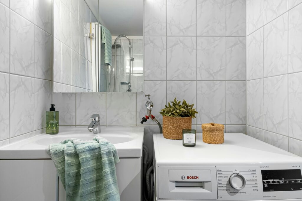 A clean and modern bathroom with integrated laundry area and elegant decor.